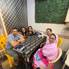 A family poses for a photo during their dinner at our banquet. The green wall accent adds a nice touch to the simple and clean decor of our hall.
