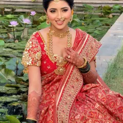 A vision of grace in classic red. We created a timeless bridal look for Diksha, featuring a stunning wing liner and a soft base, set against a serene water lily pond.