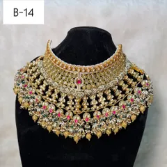 For the bride who wants ultimate grandeur, this is my B-14 heavy bridal rental set. It features intricate kundan and polki work with touches of red and green, designed to make a breathtaking statement.