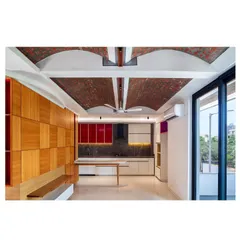 Functional spaces like kitchens can also be works of art. Here, exposed load-bearing brick vaults form the ceiling, contrasting with modern cabinetry and a custom breakfast table, proving that structural honesty and daily life can coexist beautifully.