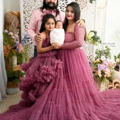 The perfect first family portrait. Mom, dad, and big sister are all coordinated in beautiful shades of pink, lovingly holding the newest member of their family. This image captures the joy and completeness that a new baby brings.
