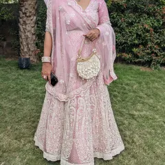 A perfect pink lehenga for a wedding party. The delicate threadwork and matching net dupatta create an elegant and sophisticated look for a wedding guest.