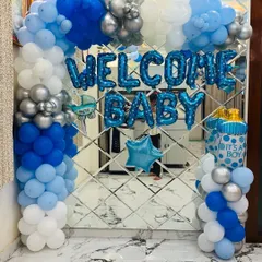 We create classic and joyful welcome home decorations for your baby boy. This setup includes a beautiful balloon arch in shades of blue, white, and silver, with "WELCOME BABY" foil letters and themed balloons like a baby bottle and star.