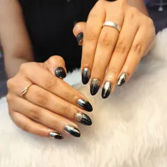 Black nails, endless possibilities. This edgy and glamorous set features a mix of black nails, gold chrome, and a sparkling black and gold glitter ombré.