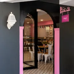 A daytime view of the Qoqobae entrance. The pink accents and whimsical "Hey!" sign add a playful touch, inviting passersby into the charming ice cream parlor.