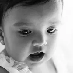 A close-up in black and white captures the sweet, innocent expression of a birthday girl. Her joy is clear even without color.