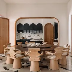 A wider view of the dining area, showing the dramatic geometric-patterned floor and the custom-designed chairs that are both sculptural and comfortable.