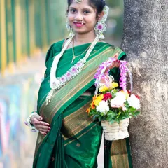 A beautiful portrait of the mom-to-be at her baby shower. Holding a basket of flowers, she is adorned in a traditional green saree and floral jewelry, ready for the ceremony.