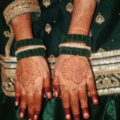 A traditional look for Eid, with simple mandala mehendi paired with green bangles and a festive outfit.