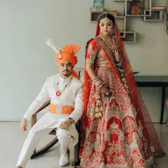 A modern royal portrait. The groom seated, the bride standing tall beside him, this pose creates a sense of partnership and regal elegance against a simple backdrop.