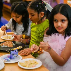 Friends enjoying a meal of pasta and other treats during a birthday party. We serve food that kids love to eat.