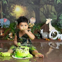 A wild first birthday! This little explorer is having the best time smashing his cake in our fun jungle-themed setup, complete with his favorite animal friends in the background.