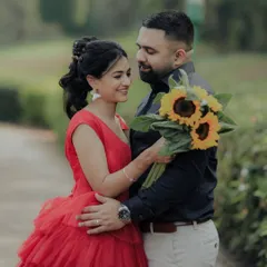 A romantic gaze shared between the couple in a serene garden setting. The sunflowers add a pop of cheerful color, symbolizing adoration and loyalty in this beautiful pre-wedding photograph.
