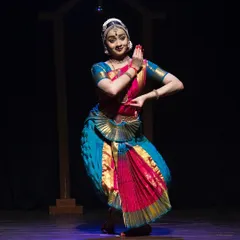 A full-body shot from the Kanasu festival, showing a classic Bharatanatyam pose with clean lines and a joyful expression.