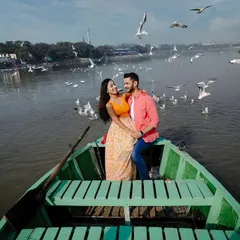 A wide shot showing the couple surrounded by a huge flock of birds on the Yamuna river. This image captures the incredible atmosphere of this popular Delhi pre-wedding shoot location.