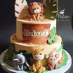 I love creating adorable jungle-themed cakes for little ones. This two-tiered chocolate cake features handmade, edible fondant animals like a lion, giraffe, and elephant, perfect for a wild first or second birthday party.
