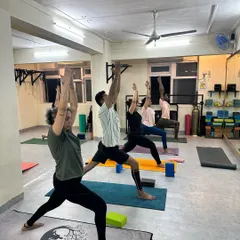 We believe movement is the best medicine for the body. Our classes are not just about achieving poses but about celebrating what our bodies can do, like in this Virabhadrasana I (Warrior I).