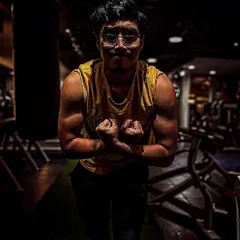 This client was on a bulk program focused on building shoulder mass. The dramatic lighting highlights the definition and size he achieved through a targeted shoulder workout plan and consistent training.