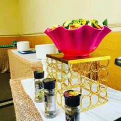 A vibrant salad bowl with various seasonings available for guests. This is part of my commitment to providing fresh, healthy, and customizable food options.