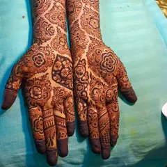 This is a very dense and detailed bridal design, where almost no skin is left bare. The patterns are a mix of floral, paisley, and geometric shapes, creating a very rich and traditional look.