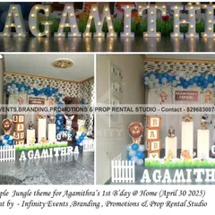 A simple jungle theme for Agamithra's first birthday at home. The decor includes a character backdrop, blue and white balloon arrangements, and large light-up letters, creating a fun and personal party space.