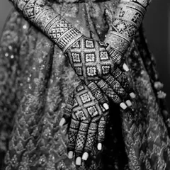 A stunning black and white shot of the bride's mehendi-adorned hands. The monochrome edit emphasizes the complexity and artistry of the design.