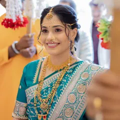 A beautiful look for another wedding function in a teal blue saree. The makeup is kept fresh and glowing, with traditional jewelry and the essential Mundavalya for the ceremony.