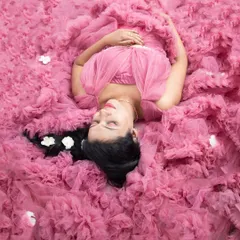 A dreamy overhead shot with the mom-to-be nestled in a cloud of pink ruffled fabric. This is such a beautiful and artistic way to capture a serene maternity moment.
