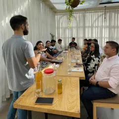 A group of participants listens as our expert explains the science behind fermentation. You can see the starter cultures and bottles on the table, ready for the hands-on portion of the workshop.