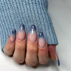 A beautiful example of a glitter ombre, with a deep blue sparkle fading into a natural pink base on long almond nails.