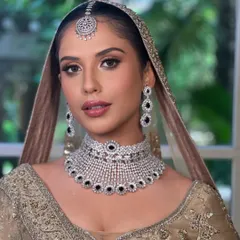 A modern-day bridal glam that is both minimal and elegant. This close-up shows the soft gold shimmer on the eyes and a flawless matte mauve lip.