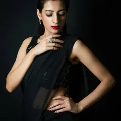A classic and elegant pose from the 'BLACKBURN' series. This three-quarter shot in a black saree showcases a sophisticated and composed look, ideal for an actor's portfolio needing a mature character shot.