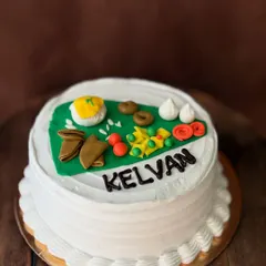 A special custom cake for a 'Kelvan' ceremony, a pre-wedding Maharashtrian ritual. The top features edible miniatures of traditional food items served during the function.