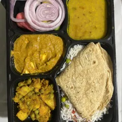 This is my standard daily vegetarian thali, perfect for your office lunch or a simple dinner. It includes soft chapatis, vegetable rice, dal, a paneer curry, a dry vegetable sabzi, and a fresh salad.