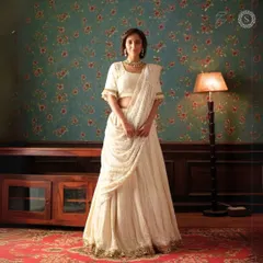 This elegant off-white lehenga with a draped dupatta is a timeless and graceful choice. It is perfect for a guest who wants to look chic and understated.