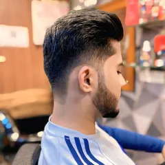 A clean and sharp look for men. This haircut features a precise skin fade on the sides that blends perfectly into the styled hair on top, creating a modern and stylish profile.