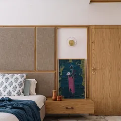 This bedroom corner in the Cocoon House showcases our focus on creating serene, personal sanctuaries. We combined a fabric-panelled headboard with a natural wood frame, setting it against a backdrop of carefully chosen art and soft textiles to create a space that feels both minimalist and lived-in.
