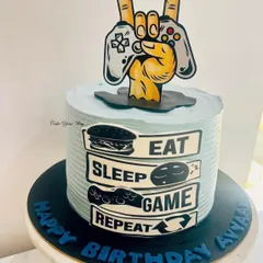 Eat, Sleep, Game, Repeat. This cake is for the ultimate gamer, featuring a controller and the gamer's life motto.