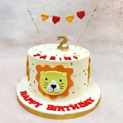 We celebrate a little cub's birthday with this cheerful cartoon lion cake. A friendly lion face, festive bunting, and a glittering number "2" candle make this a bold and playful centerpiece for a jungle-themed party.