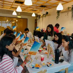 A team of colleagues deeply engaged in a canvas painting session. I love bringing art into the workplace to provide a creative and refreshing break.