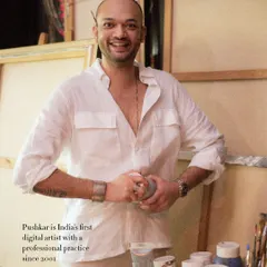 A happy, candid portrait of artist Pushkar Thakur in his studio. His smile and the creative chaos around him perfectly capture his vibrant energy.