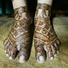 A full-coverage foot mehendi with a dense 'jaal' or net pattern, perfect for a bride who wants a very traditional and rich look.
