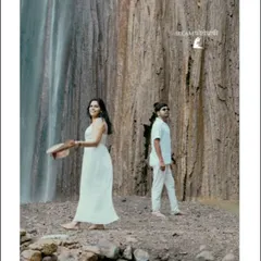 A candid moment by a majestic waterfall in Rishikesh. The natural setting and the couple's relaxed posture create a feeling of peaceful romance.