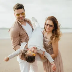 A fun and playful family moment on the sand, with the birthday boy held upside down. These candid shots create the best memories.