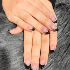 A modern twist on a classic. These almond-shaped extensions feature a sharp black French tip with a subtle silver glitter fade, creating a sophisticated and edgy look.