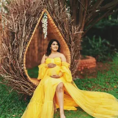 The sunlight filtering through the trees adds a magical touch to this outdoor portrait. The flowing yellow gown looks absolutely breathtaking in this natural setting.