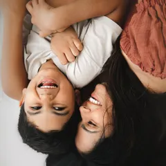 Pure, uninhibited joy. This overhead shot captures a mother and son sharing a moment of playful laughter, a memory that truly reflects the happiness of their bond.