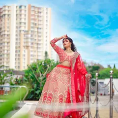 A full-length view of the stunning bridal lehenga, perfect for an outdoor photoshoot. The contrast between the cream skirt and the red dupatta is simply breathtaking.