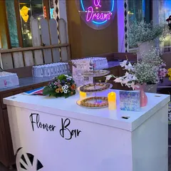 The 'Flower Bar' cart, complete with fresh blooms and a neon sign, was a highlight of the celebration.