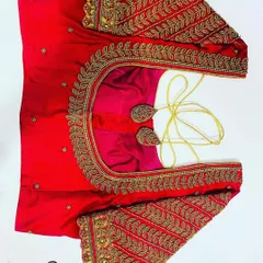 This bright red blouse features heavy, traditional leaf-motif embroidery in gold thread. The work covers the entire sleeve and neckline, making it perfect for a pattu saree.